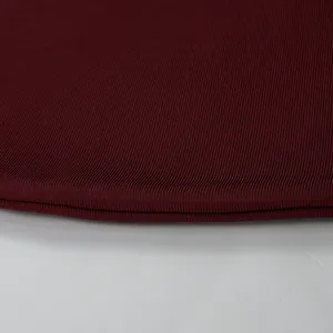 Close-up detail of high-quality burgundy ribbed bandage fabric with clean hemline
