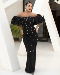 Elegant black off-shoulder evening dress featuring beaded details and ruffled sleeves