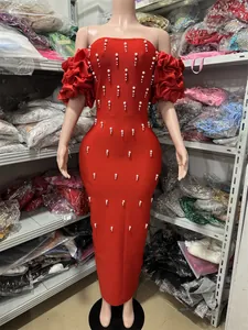 Detailed view of red bodycon maxi dress featuring elegant pearl decor and ruffles