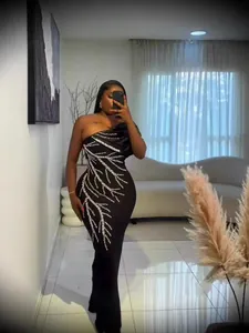 Elegant black one-shoulder party dress with silver sequin branch pattern detail.