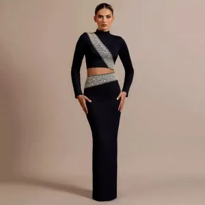 Elegant black two-piece set featuring long sleeve crop top and rhinestone maxi skirt