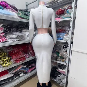 Elegant white two-piece set with long-sleeved crop top and high-waisted maxi skirt