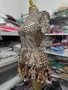 Dettaglio laterale di un abito da spettacolo con paillettes color oro su un manichino