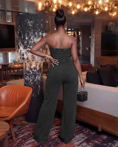 Detail view of washed strapless wide-leg jumpsuit on a model in a luxury lounge.
