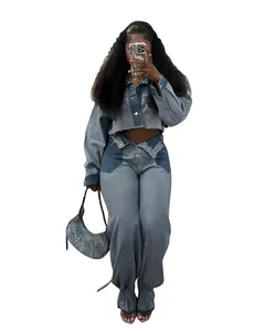 Detail view of a trendy two-piece color-block denim set on a model holding a bag