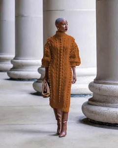 Detail view of a model wearing a brown cable knit turtleneck dress with puff sleeves