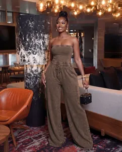 Detailed view of women's strapless washed brown wide-leg jumpsuit in lounge setting