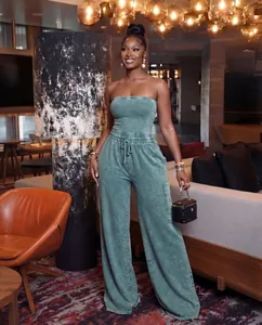 Lifestyle view of a model wearing a washed green strapless wide-leg jumpsuit