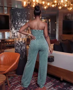 Back view of a sage green strapless washed wide-leg cargo jumpsuit on a model.