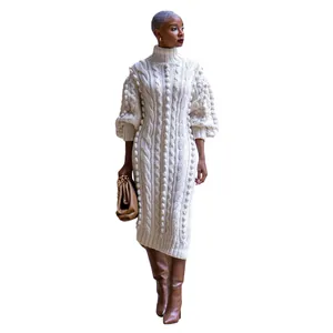 Detailed view of pom-pom and cable knit texture on a cozy winter high-neck dress