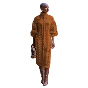 Full length view of a caramel cable knit turtleneck maxi dress with pom-pom details.