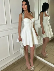 Elegant white halter mini dress featuring sparkling rhinestones and a corset style bodice