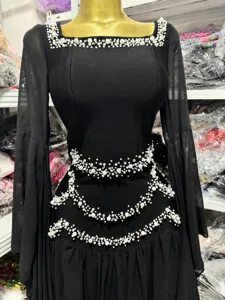 Close-up of black bodycon dress featuring elegant pearl embellishments and bell sleeves