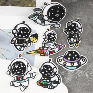 Detailweergave van schattige geborduurde astronauten en UFO strijkpatches voor kleding.