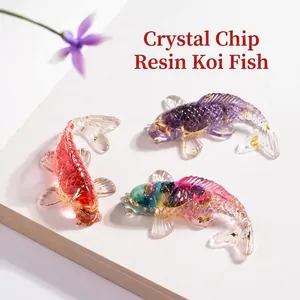 Detalle de tres figuras de peces koi de resina con pan de oro y cristales incrustados