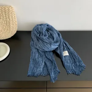 Detailed close-up of a blue pleated cotton linen scarf with delicate fringe edges
