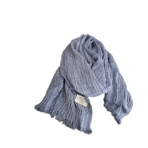 Elegant solid blue pleated cotton linen scarf with tassel fringe on white background