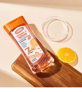 Détail de l'huile corporelle à la vitamine C sur planche en bois et orange