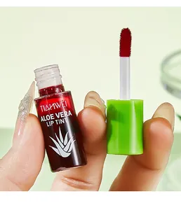 Detail shot of red aloe vera lip tint with applicator brush held by hand.