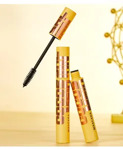 Detail view of the mascara wand brush and the bright yellow tube with metallic lettering