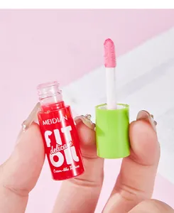 Close-up detail of MEIDIAN lip oil showing pink applicator and its creamy texture