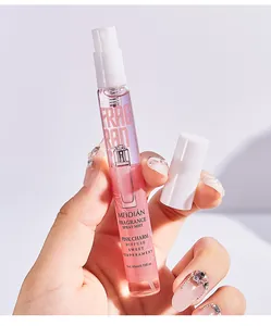 Primer plano de bruma de fragancia MEIDIAN Pink Charm 10ml sostenida por una mano decorada