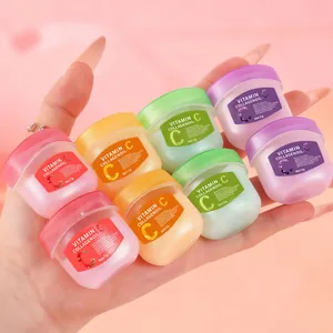 Detail view of colorful Vitamin C Collagen lip mask jars held in hand for hydration