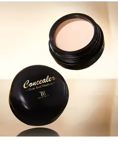Gros plan de l'anti-cernes crème Tao Beauty avec détails dorés