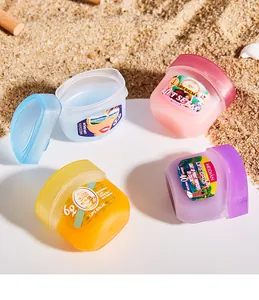 Set of four MEIDIAN moisturizing lip masks in colorful jars on beach sand background