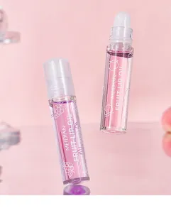 Twee flessen Meidian fruit lipolie met rollerball applicator op een roze achtergrond