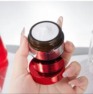 Primer plano de la rica textura cremosa blanca en un tarro rojo de crema para el rostro
