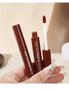 Detailed close-up view of chocolate matte lip glaze with soft applicator held by a hand