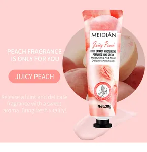 Detail of peach fragranced hand cream tube with moisturizing texture smear.