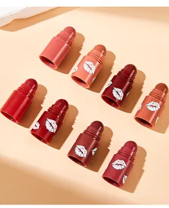 Detailed view of multiple lipstick shades with white lip print patterns on beige background.