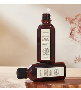 Detailopname van Bosuya Marokko haarolie in amberkleurige flessen van 60 ml op hout