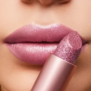 Vista macro de la textura del labial rosa brillante y su efecto de aplicación en los labios
