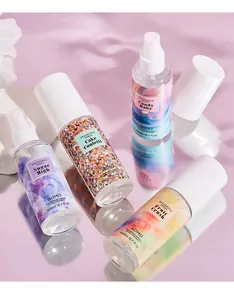 Plan rapproché de flacons de parfum ADMD colorés sur une surface violette réfléchissante.
