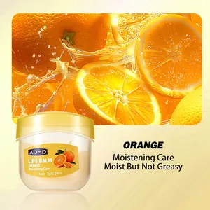 Detailed view of ADMD orange moisturizing lip mask jar against fresh citrus background