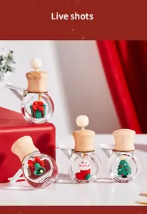 Detalle de frascos de perfume de vidrio para coche con temas navideños y tapas de madera.