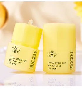 Detail showing two FORMBO Little Honey Pot moisturizing lip balm containers in yellow