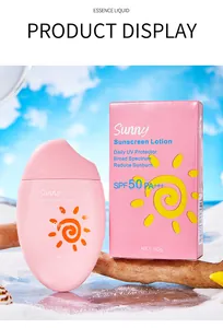 Détail de la lotion solaire Sunny SPF50 et de son emballage rose sur un décor de plage