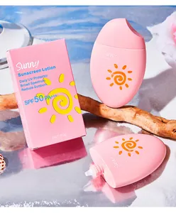 Gros plan sur un flacon de lotion solaire rose SPF 50 sur une surface réfléchissante