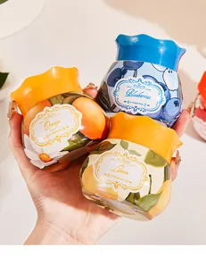 Gros plan de pots d'aromathérapie naturelle aux parfums orange, myrtille et citron