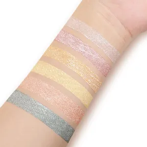 Detailed view of six shimmer liquid eyeshadow swatches on skin in gold and silver