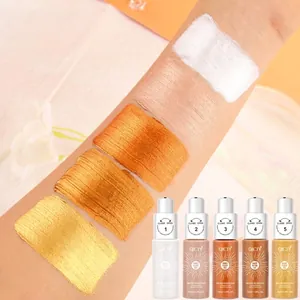 Gedetailleerde macro-weergave van vijf verschillende glinsterende lichaamsolie-swatches op de huid