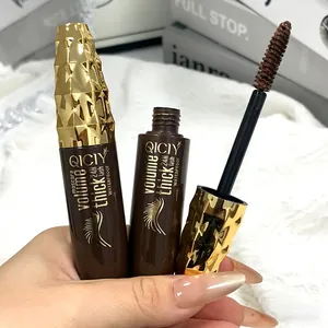 Close-up of brown mascara wand and gold studded packaging for volume and length