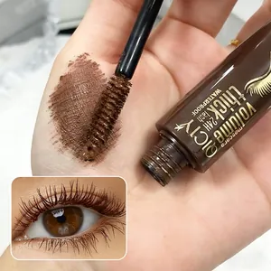 Close-up of QICIY brown mascara wand showing waterproof texture and color swatch on skin
