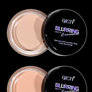 Close-up of QICIY blurring putty concealer in beige shade on black background