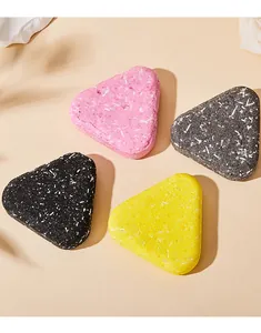 Detailed macro view of four triangular scented bar soaps in pink, yellow, and black