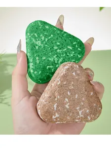 Vista detallada de dos jabones artesanales triangulares para cabello y cuerpo en verde y marrón